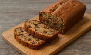 Pyszny chlebek bananowy bezglutenowy z kawałkami czekolady, pokrojony na desce.