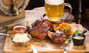 Pyszna golonka w piwie przepis na obiad. Podana z ziemniakami, kapustą i kuflem piwa.