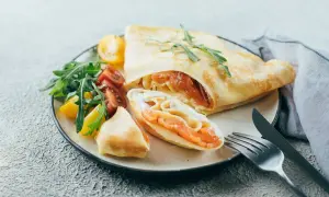 Naleśniki z łososiem i serkiem, podane z rukolą i pomidorkami. Pyszna kolacja bez chleba.