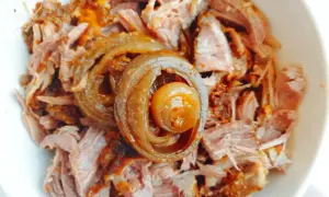 Miseczka z pysznym, szarpanym pulled pork, ozdobiona karmelizowaną cebulką. Idealne do kanapek i burgerów.
