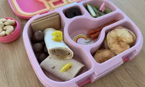 Kolorowe śniadanie dla 3 latka: wrap z żółtym pieskiem, ciasteczka, orzeszki, suszone jabłka, kiwi i czekoladowe kuleczki.