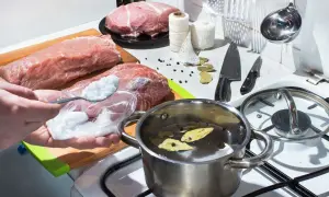 Przygotowania do peklowania na mokro: mięso, sól, przyprawy i garnek z zalewą na kuchence.