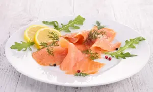 Eleganckie carpaccio z łososia, ozdobione rukolą, cytryną i koperkiem, kusi delikatnym smakiem.