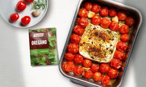 Pieczona feta z pomidorami i czosnkiem, doprawiona oregano. Pyszne danie gotowe do podania.