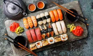 Z czym można zrobić sushi? Na talerzu krewetki, łosoś, tuńczyk, węgorz, ryż, nori, imbir, wasabi i sos sojowy.