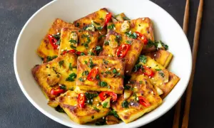 Chrupiące, złociste kostki tofu w sosie sojowym, posypane chili, sezamem i natką pietruszki. Idealne danie dla miłośników azjatyckich smaków.