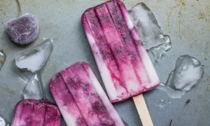 Dwa pyszne, domowe lody na patyku z wiśniami i kawałkami lodu.