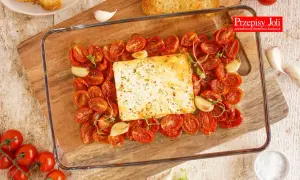 Pyszna feta zapiekana z pomidorkami koktajlowymi, czosnkiem i ziołami. Idealna na przystawkę lub lekki posiłek.