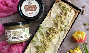 Nowoczesny mazurek wielkanocny z kremem pistacjowym. Idealny na święta, udekorowany pistacjami i gałązką mięty.