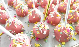 Różowe cake pops z kolorową posypką i króliczkami, idealne na wielkanocny przepis.