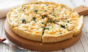 Pyszna tarta z łososiem, szpinakiem i serem feta, pokrojona na kawałki, gotowa do podania.