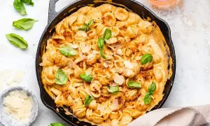 Orecchiette w kremowym sosie z suszonych pomidorów, posypane parmezanem i świeżą bazylią. Pyszne danie, które zachwyci każdego.