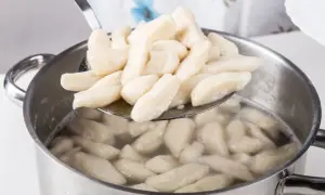 Gotowane kopytka na łyżce cedzakowej. Czy kopytka można mrozić? Tak, można je zamrozić przed lub po ugotowaniu.