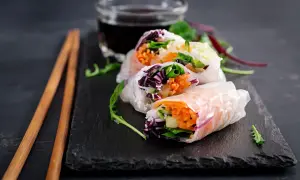 Świeże spring rolls z warzywami i ryżem, podane z sosem.