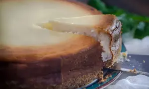 Idealny sernik, który nie opadł, z wyciętym kawałkiem. Poznaj sekrety, co zrobić żeby sernik nie opadł i cieszyć się jego perfekcyjnym wyglądem.