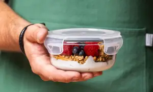 Pyszne jedzenie na podróż: jogurt z granolą, malinami i borówkami w szklanym pojemniku. Idealne na wycieczkę!
