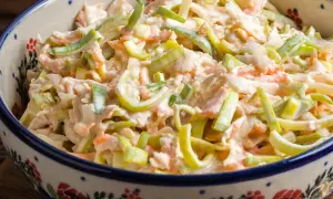 Szybka sałatka z pora i marchewki w kremowym sosie, podana w ozdobnej misce. Idealna na szybki lunch.