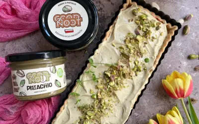 Nowoczesny mazurek wielkanocny z kremem pistacjowym. Idealny na święta, udekorowany pistacjami i gałązką mięty.