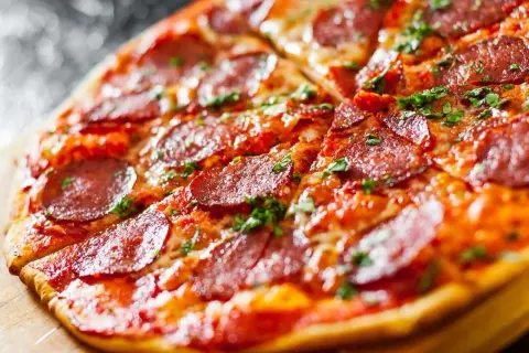 Apetyczna pizza bez drożdży z pikantnym salami i posypką z ziół, idealna na szybki obiad.
