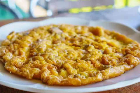 Złocisty omlet na białym talerzu, idealny omlet na kolację.
