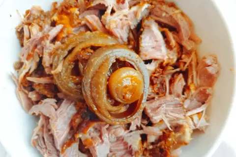 Miseczka z pysznym, szarpanym pulled pork, ozdobiona karmelizowaną cebulką. Idealne do kanapek i burgerów.