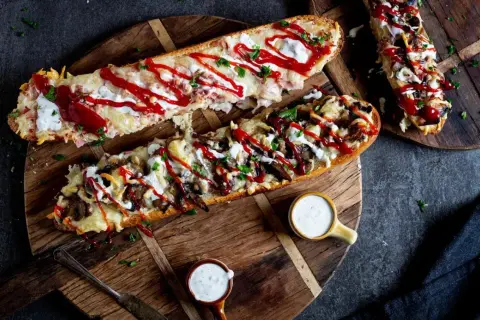 Pyszny domowy fast food: zapiekane bagietki z serem, pieczarkami i sosem. Idealne na szybki posiłek.