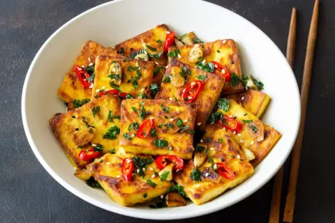 Chrupiące, złociste kostki tofu w sosie sojowym, posypane chili, sezamem i natką pietruszki. Idealne danie dla miłośników azjatyckich smaków.