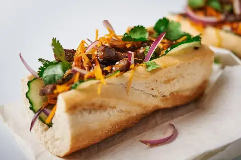Pyszny banh mi przepis: bagietka z wołowiną, ogórkiem, marchewką, kolendrą i czerwoną cebulą.