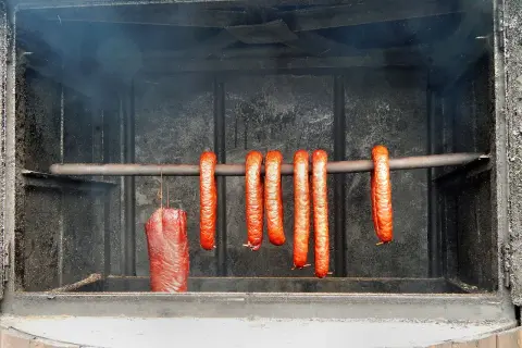 Wędzenie szynki i kiełbasek w wędzarni. Kluczowa jest odpowiednia temperatura, by uzyskać idealny smak.