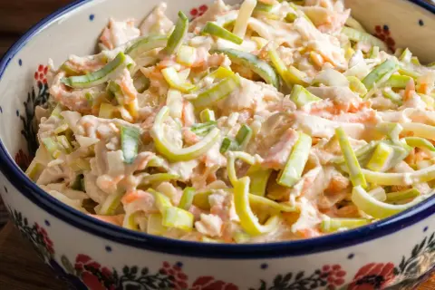 Szybka sałatka z pora i marchewki w kremowym sosie, podana w ozdobnej misce. Idealna na szybki lunch.