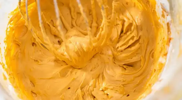 Gładka, kremowa masa z mascarpone, ubijana trzepaczką miksera, gotowa do deseru.