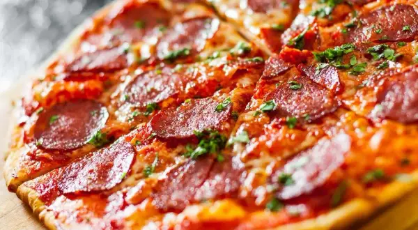 Apetyczna pizza bez drożdży z pikantnym salami i posypką z ziół, idealna na szybki obiad.
