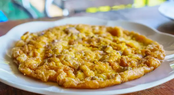Złocisty omlet na białym talerzu, idealny omlet na kolację.