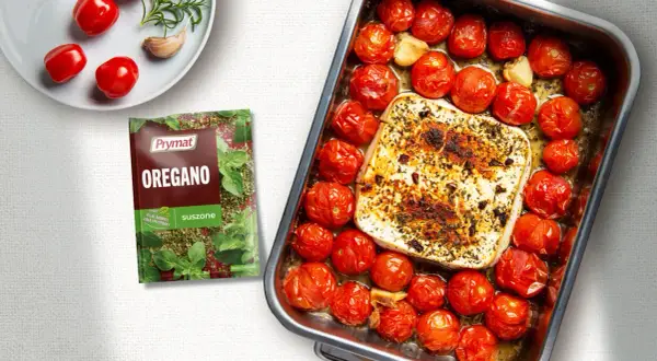 Pieczona feta z pomidorami i czosnkiem, doprawiona oregano. Pyszne danie gotowe do podania.