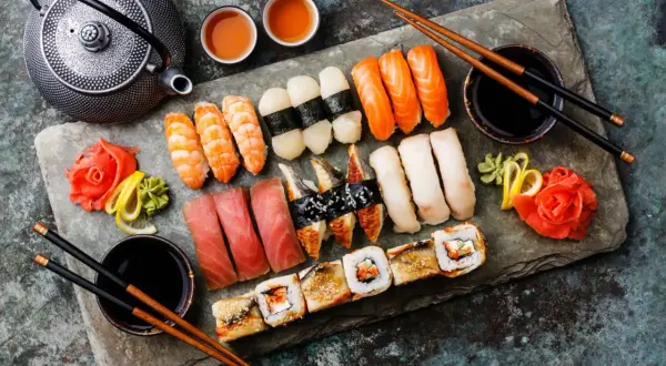 Z czym można zrobić sushi? Na talerzu krewetki, łosoś, tuńczyk, węgorz, ryż, nori, imbir, wasabi i sos sojowy.