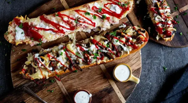 Pyszny domowy fast food: zapiekane bagietki z serem, pieczarkami i sosem. Idealne na szybki posiłek.