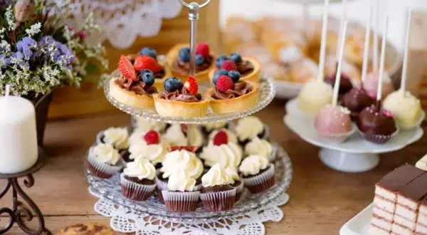 Słodkie przekąski na imprezę: babeczki, tartaletki z owocami, cake pops i ciasto.
