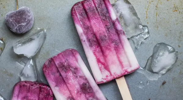 Dwa pyszne, domowe lody na patyku z wiśniami i kawałkami lodu.