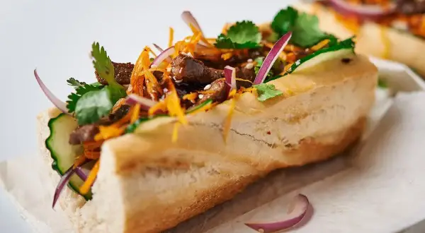 Pyszny banh mi przepis: bagietka z wołowiną, ogórkiem, marchewką, kolendrą i czerwoną cebulą.