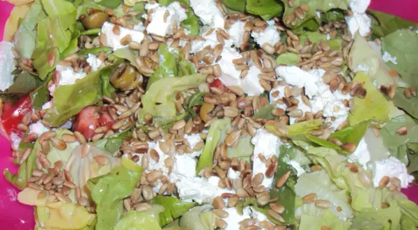 Sałatka na ognisko: świeża sałata, ser feta, oliwki i słonecznik. Idealna na letnie wieczory.