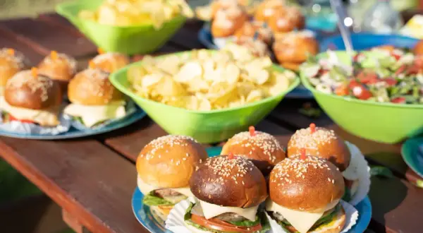 Mini burgery i chipsy na stole – idealne przekąski na szybko dla gości.
