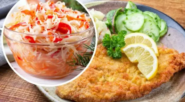 Idealna surówka do gołąbków to ta z kapusty z marchewką i papryką. Na talerzu kotlet schabowy z ziemniakami i ogórkiem.