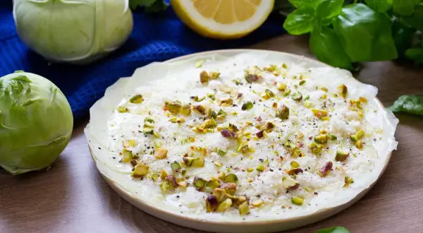 Delikatne carpaccio z kalarepy, posypane pistacjami i parmezanem, z dodatkiem świeżej bazylii i cytryny.