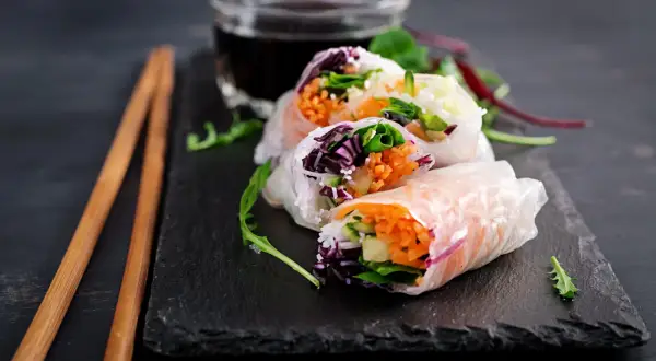 Świeże spring rolls z warzywami i ryżem, podane z sosem.