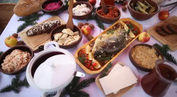 Wielkanocny stół pełen tradycyjnych potraw: ryba, pierogi, kapusta, chleb i surówki. Inspiracje na przepisy na wielkanoc.