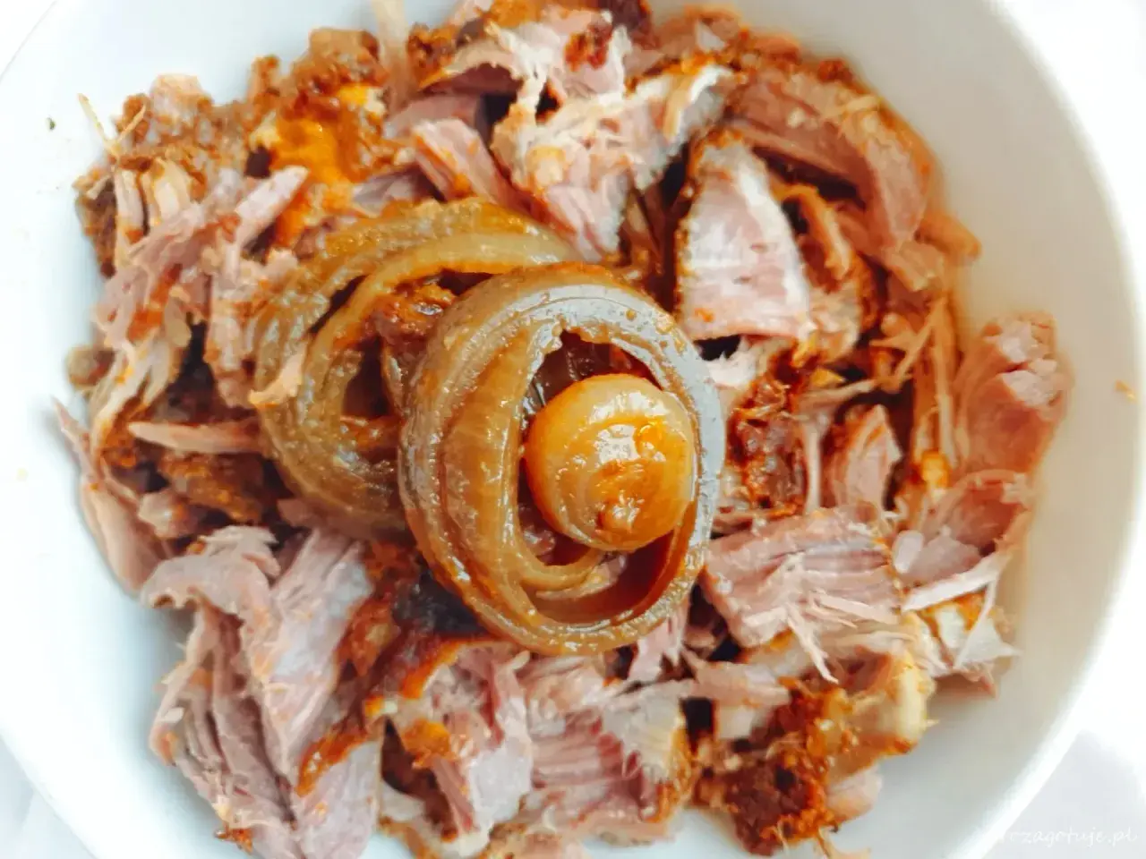 Miseczka z pysznym, szarpanym pulled pork, ozdobiona karmelizowaną cebulką. Idealne do kanapek i burgerów.