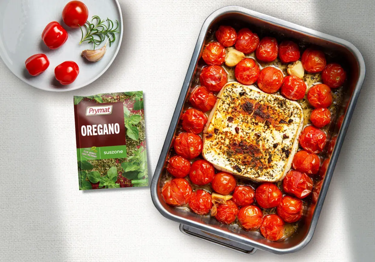 Pieczona feta z pomidorami i czosnkiem, doprawiona oregano. Pyszne danie gotowe do podania.
