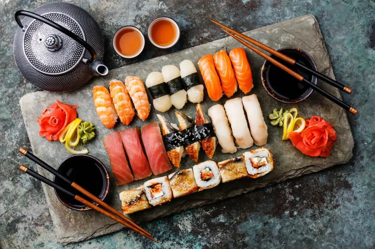 Z czym można zrobić sushi? Na talerzu krewetki, łosoś, tuńczyk, węgorz, ryż, nori, imbir, wasabi i sos sojowy.