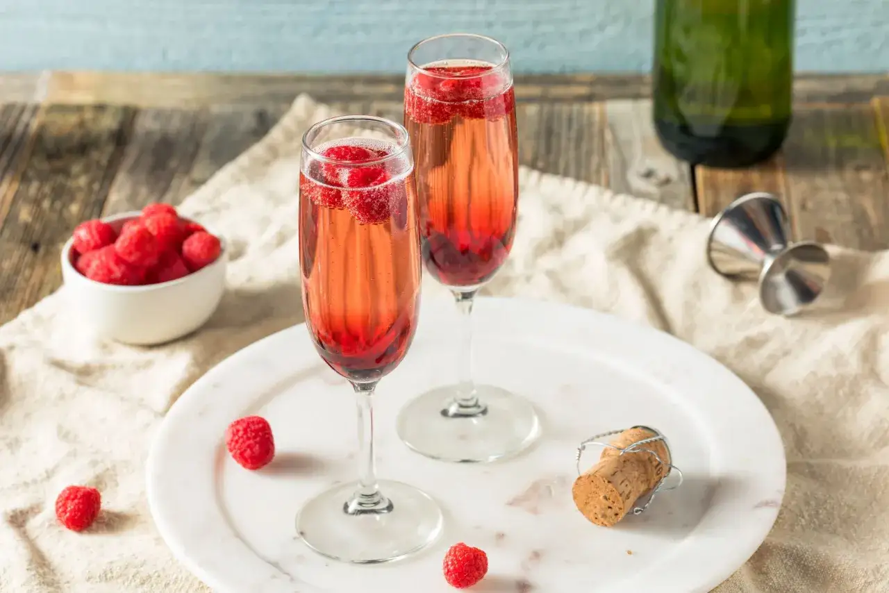 Dwa eleganckie kieliszki z orzeźwiającymi drinkami z prosecco i malinami, gotowe na toast.