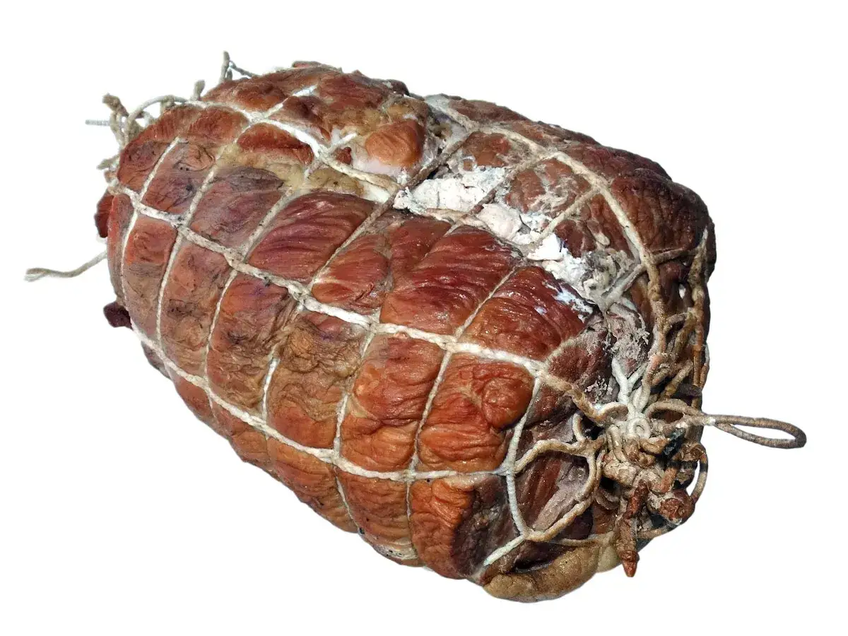 Wędzona szynka w siatce, gotowa do dalszej obróbki. Zastanawiasz się, jak długo wędzić szynkę, by uzyskać idealny smak?
